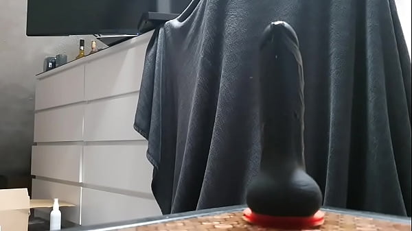 Sissy fucks her ass with a big black dildo