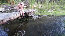 Naked on a log and in the stream.