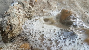 Close up frothy piss in the sand on the beach