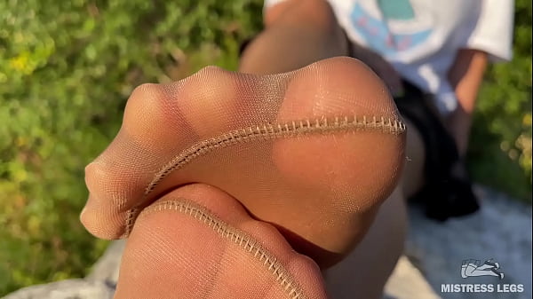 Mistress in tan tights teases you with her cute feet outdoors Thumbnail