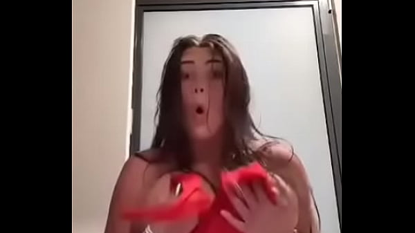 Peitos grandes caem do vestido vermelho