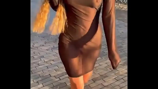 loira de vestido transparente andando pela rua
